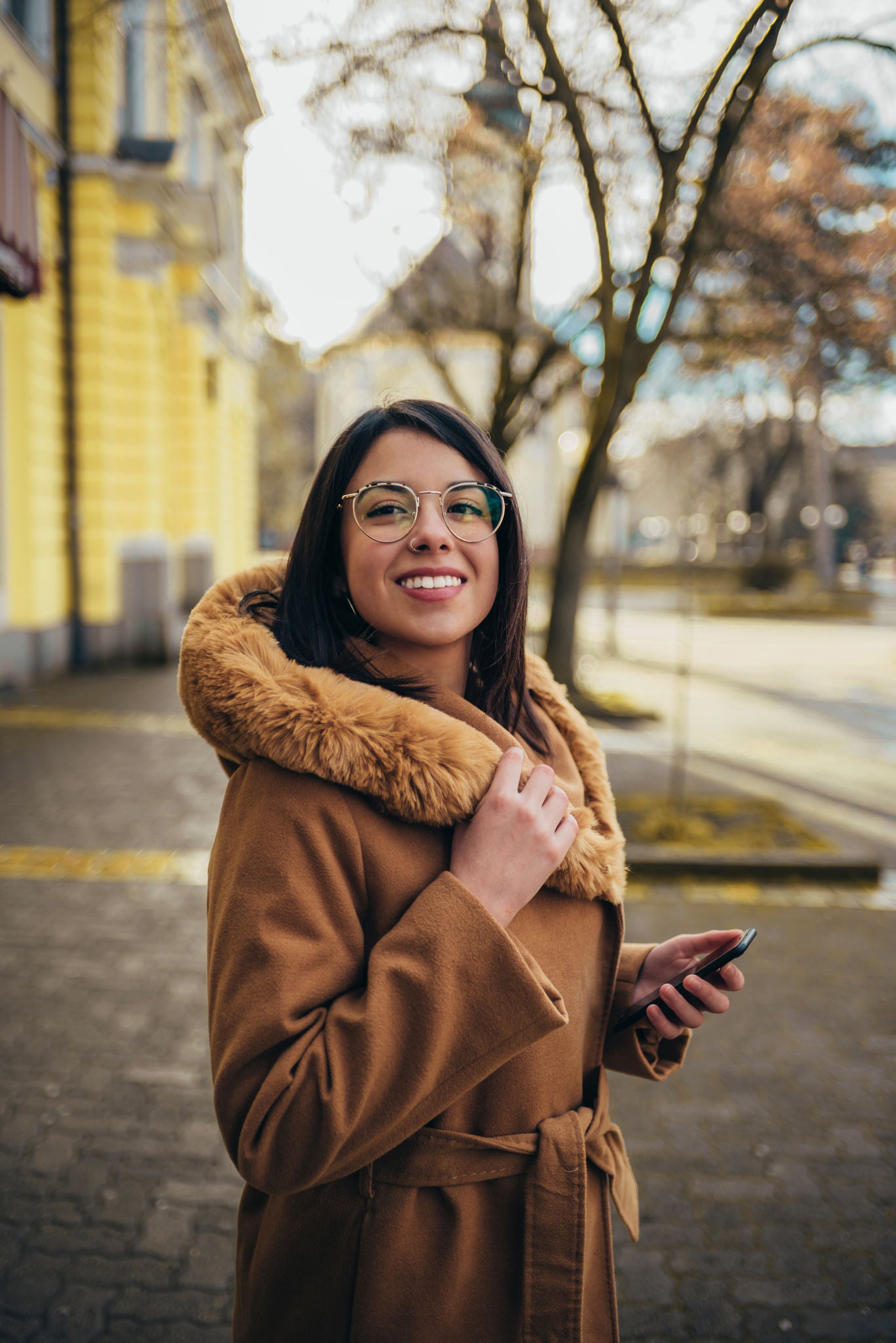 Young hispanic woman using a smartphone while out in the city