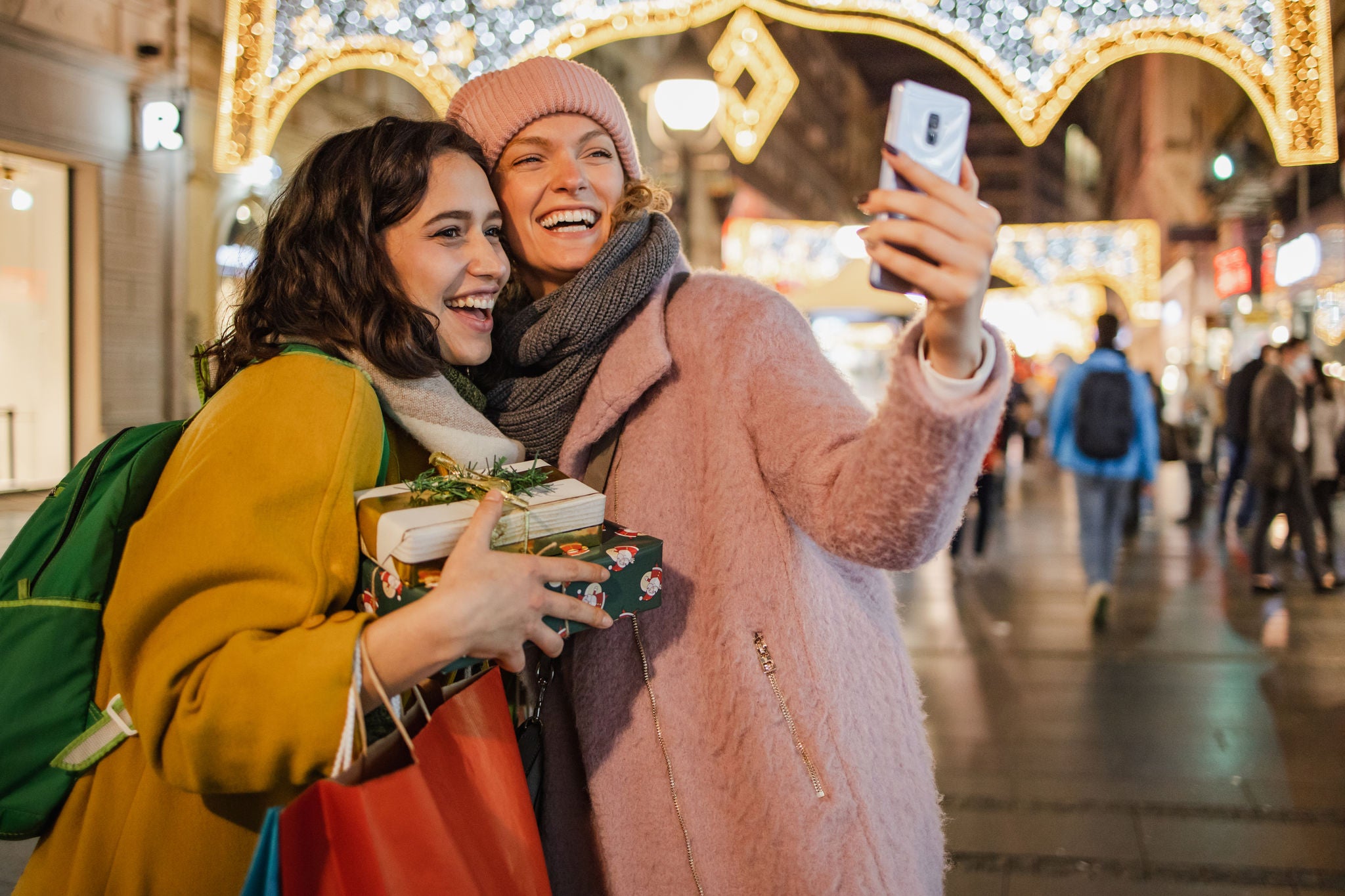 Two young woman with shopping bags in the city taking a selfie