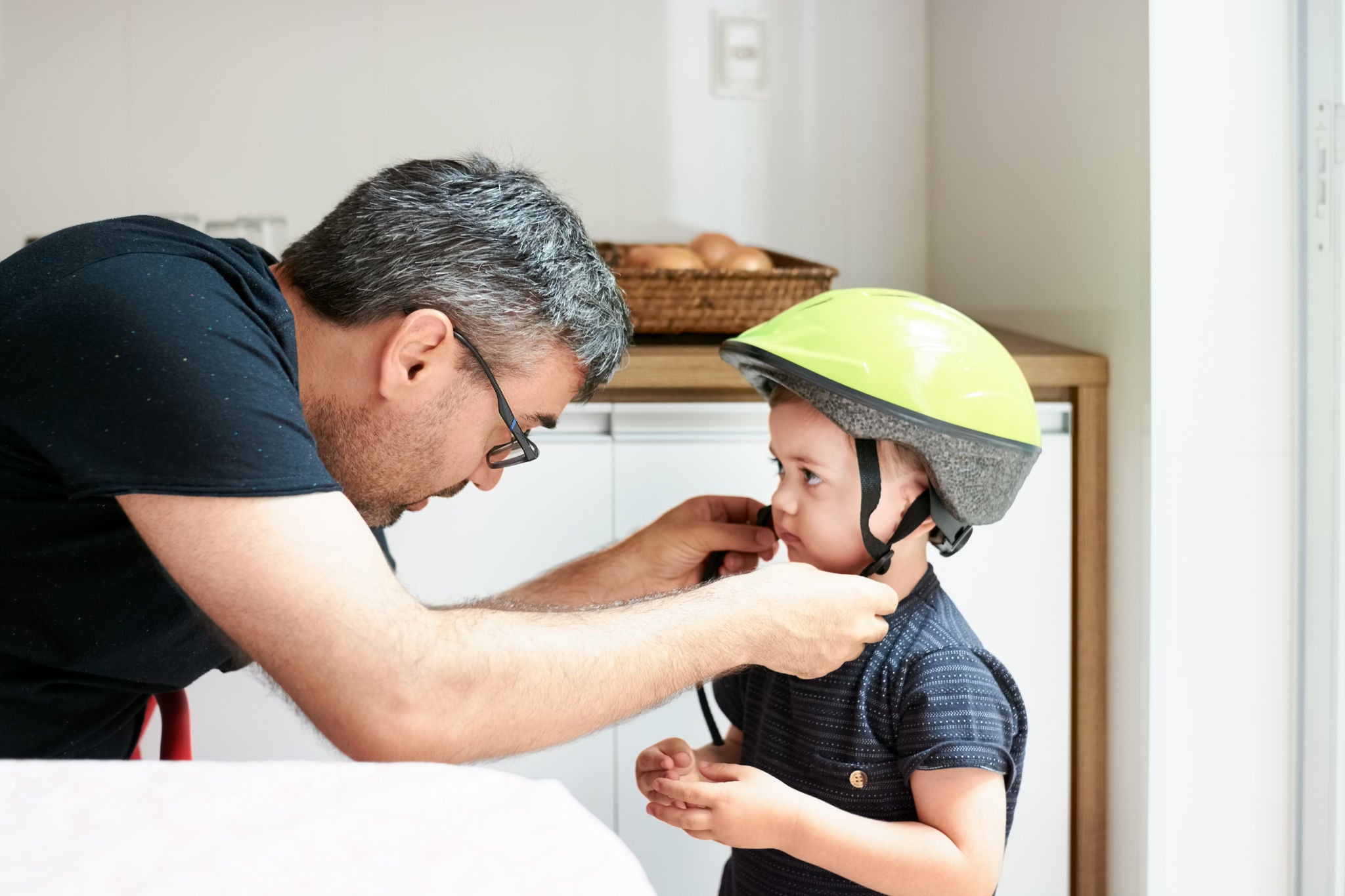 Shot of a father helping son put on helmet for cycling