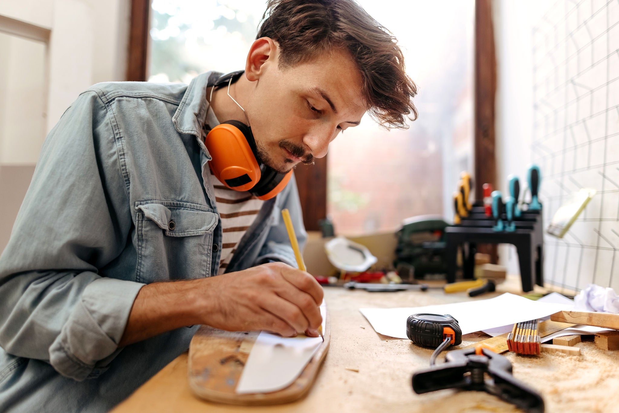 Men enjoying her hobbies at home, making her skateboard